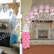 Balloon arch for baby shower made with blue and pink balloons shaped like baby bottles by balloon masters