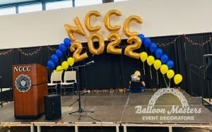 The words "NCCC 2022" at the top of two arches made from blue and yellow singular balloons.