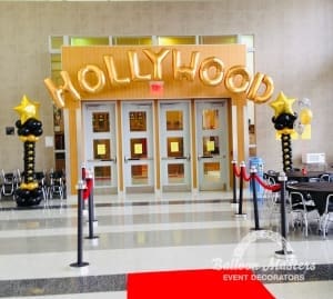 the words "Hollywood" strung above a doorway with black and gold columns on either side of doorway.